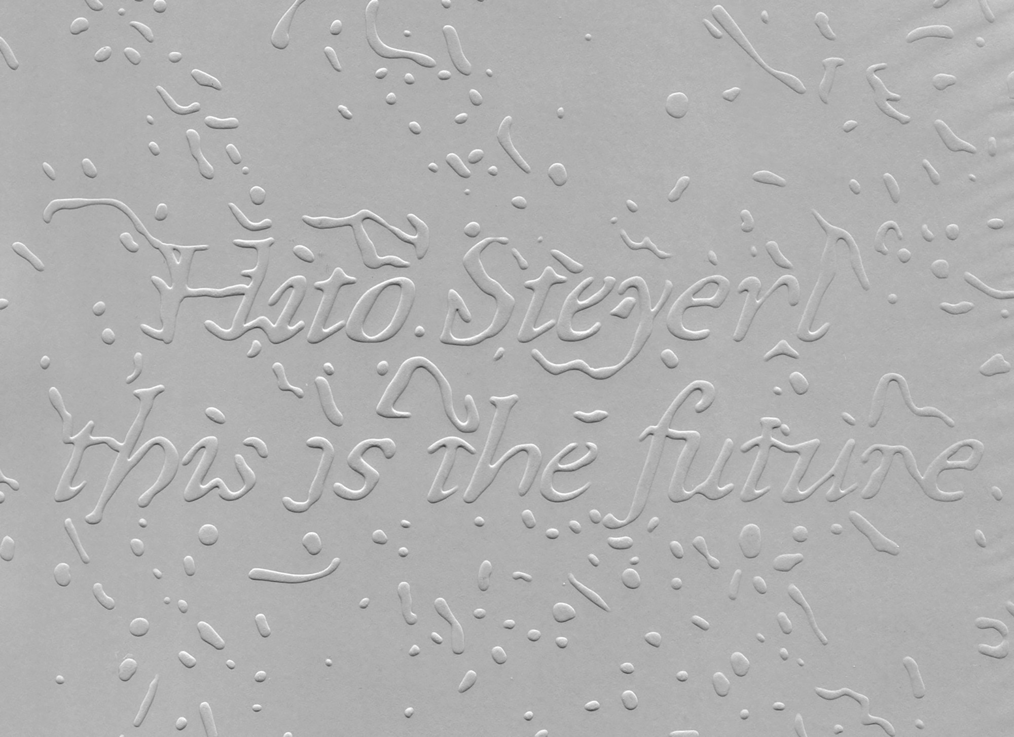 A close-up of a gray book cover. The letters are centered and embossed, surrounded by particles in different sizes.